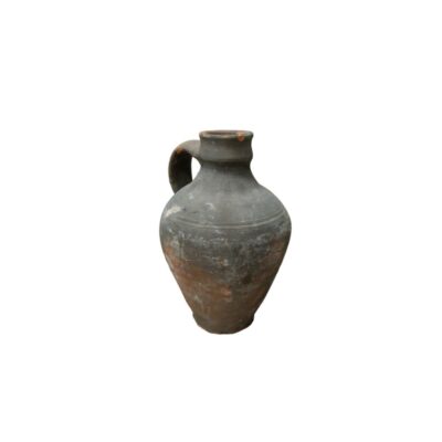 A ceramic vessel with an aged finish in dark and greyish tones, characterised by a rounded, bulbous body, a narrow base, a short neck with a moulded rim and a single arched handle on one side; available for hire for events, advertising, films and TV series