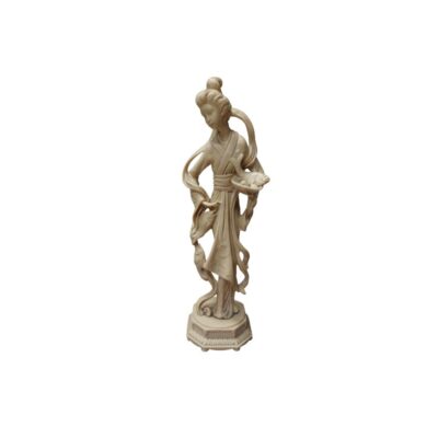 estatuilla esculpida en tono marfil claro, caracterizada por la representación de una figura femenina con vestimentas tradicionales drapeadas, un peinado recogido y sosteniendo o flanqueada por varios peces que cuelgan y reposan en sus manos, todo ello montado sobre una base poligonal tallada alquiler para eventos, publicidad, peliculas y series