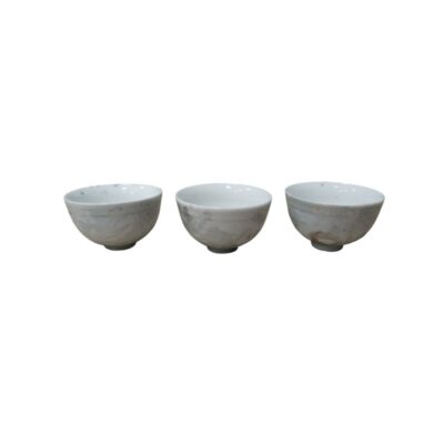 A set comprising three small ceramic bowls with a light-coloured finish and subtle signs of wear or patina typical of antique pieces; available for hire for events, advertising, films and TV series