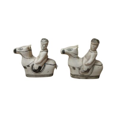 conjunto consta de dos piezas escultóricas artesanales que representan a figuras humanas montadas sobre caballos, talladas en un material de tono marfil con detalles marcados en líneas oscuras para definir los rasgos, las monturas y los arreos alquiler para eventos, publicidad, peliculas y series