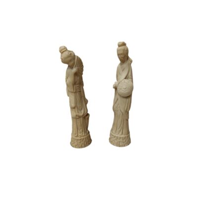 A pair of figurines, carved from a material that mimics the texture and appearance of ivory, depicting figures from Eastern iconography in detailed traditional dress