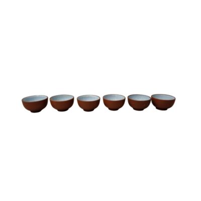 six small ceramic bowls with an earthy brown exterior finish and a matt texture, characterised by a light-coloured glazed interior with a subtle speckled effect; available for hire for events, advertising, films and TV series