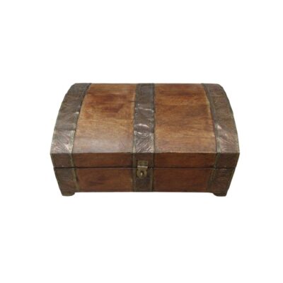 A wooden trunk with a rustic finish in dark brown tones, featuring a domed lid, a metal clasp at the front and metal bands engraved with plant motifs that reinforce its structure; available for hire for events, advertising, films and TV series