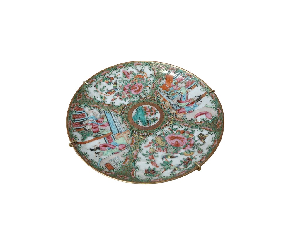 plato decorativo de porcelana que presenta una intrincada ornamentación dividida en paneles. La superficie alterna representaciones de figuras humanas en escenas cotidianas o cortesanas con motivos florales y botánicos detallados, todo enmarcado por un fondo decorado con patrones de color verde alquiler para eventos, publicidad, peliculas y series