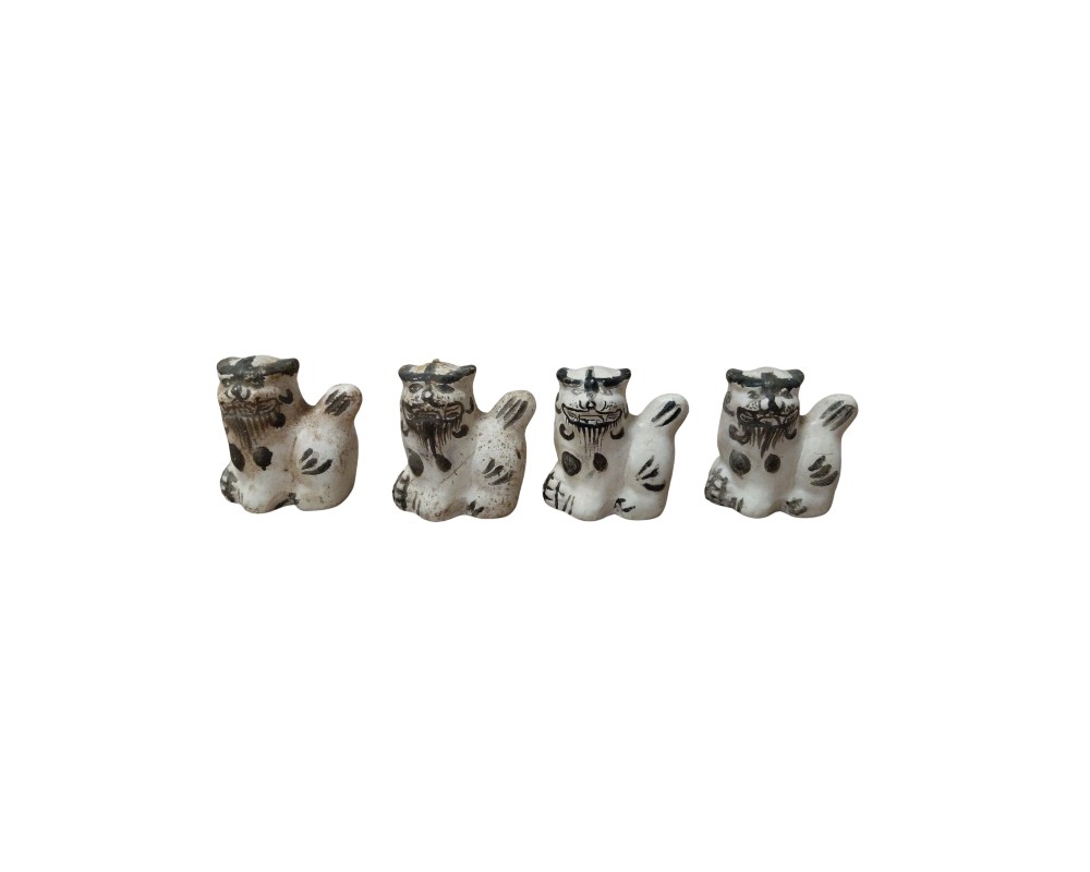 conjunto consta de cuatro pequeñas figuras escultóricas que representan a leones guardianes o perros de estilo tradicional, elaboradas en un material de tono claro con detalles pintados en color oscuro para resaltar sus rasgos faciales, melena y extremidades alquiler para eventos, publicidad, peliculas y series