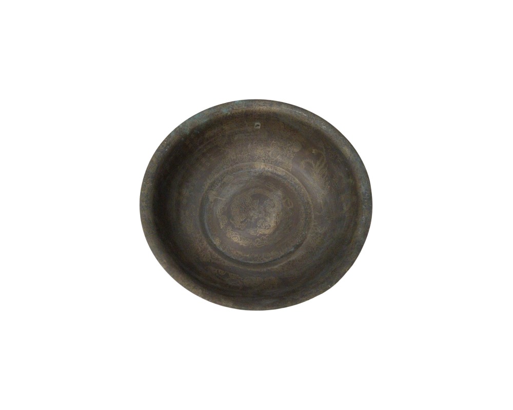 cuenco metálico con un acabado oscuro y envejecido, caracterizado por una forma circular abierta y una superficie interior completamente decorada con finos grabados tradicionales que presentan motivos ornamentales en el fondo y las paredes alquiler para eventos, publicidad, peliculas y series