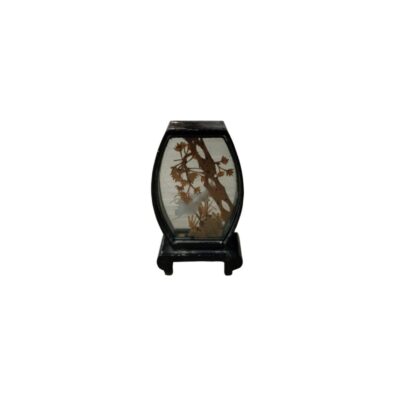 A miniature decorative object with a dark hexagonal frame and a stand, featuring an embossed diorama inside depicting an oriental natural landscape with flowering branches and stylised elements; available for hire for events, advertising, films and TV series