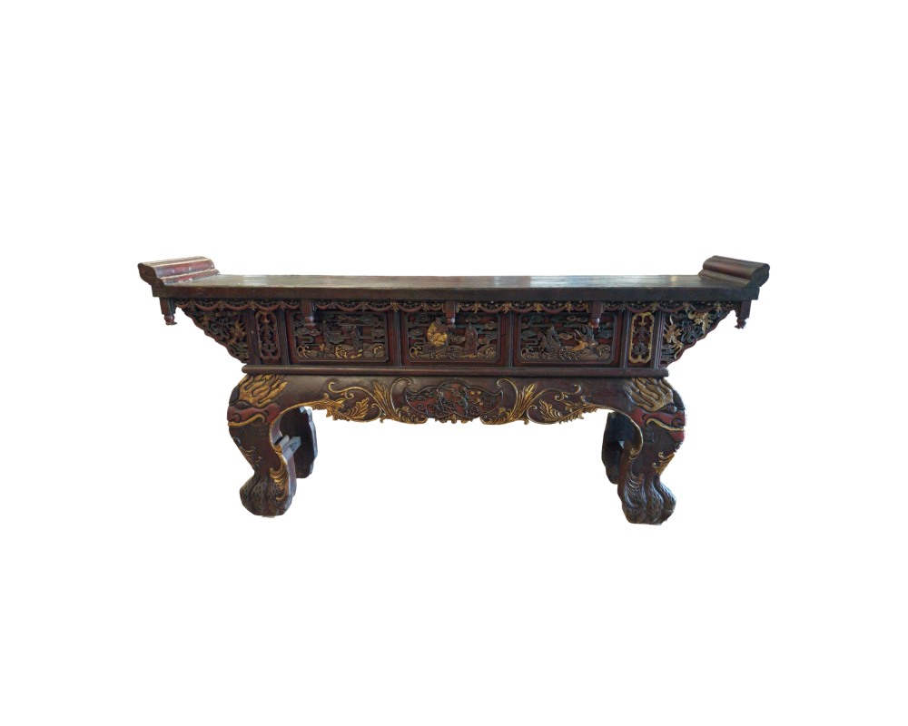 An altar table in a traditional Oriental style with dark finishes, characterised by a rectangular top with raised edges, front panels featuring intricate carved and gilded reliefs depicting figures or scenes, and sturdy, ornate legs; available for hire for events, advertising, films and TV series