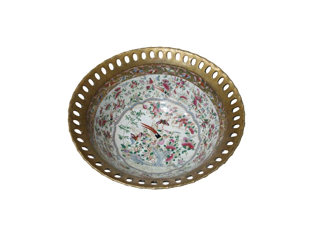 El cuerpo presenta un intrincado patrón floral con motivos de aves en tonos vibrantes, creando un contraste armonioso con su característico borde dorado de estilo calado. Este centro de mesa no solo es una pieza funcional, sino un elemento decorativo de gran valor estético, ideal para quienes buscan añadir un toque de distinción, historia y finura clásica a su decoración interior.