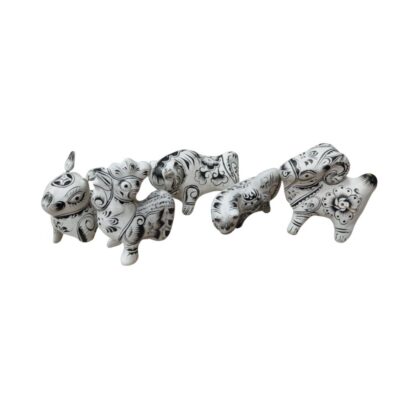 figuras escultóricas que representan a diversos animales de formas estilizadas, elaboradas en un material de tono claro y decoradas minuciosamente con intrincados motivos florales y geométricos pintados en color negro alquileres para eventos, publicidad, peliculas y series