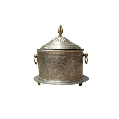 A metal container with a silver finish, fitted with a lid, ring-shaped side handles and a base with legs. The surface features detailed engravings of plant and ornamental motifs; available for hire for events, advertising, films and TV series