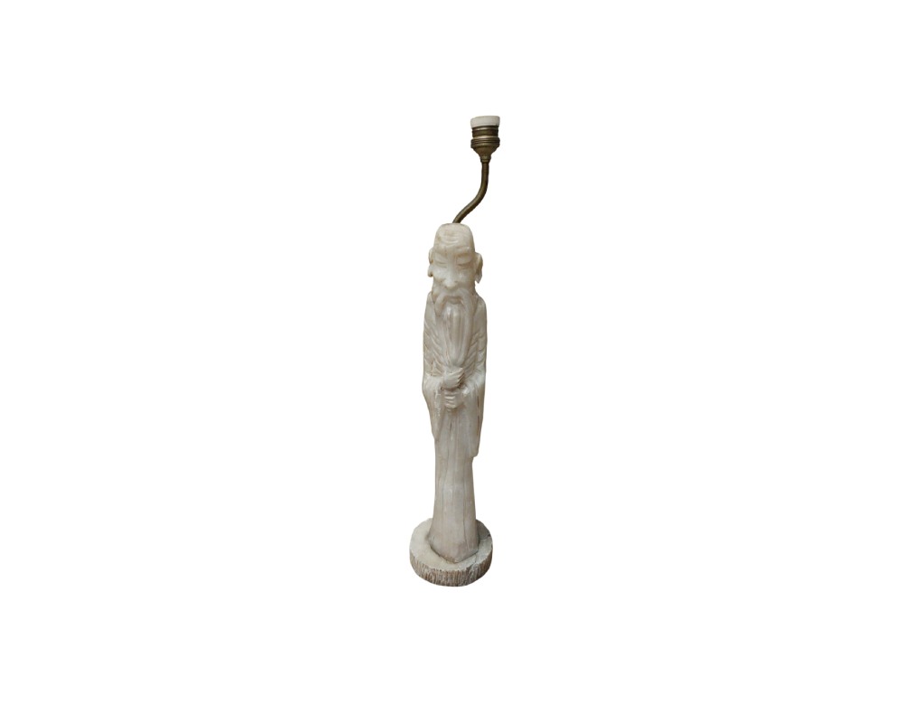 A table centrepiece based on a carved figure with an ivory-like appearance, depicting a wise old man in traditional robes, fitted with a metal stem and an upper lamp holder; available for hire for events, advertising, films and TV series