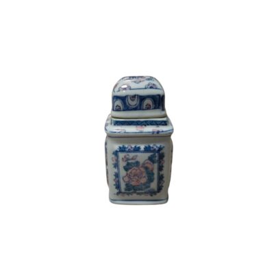 A small square porcelain jar with a matching lid. The piece features detailed cobalt blue decoration on a white background, accented with subtle touches of pink in the floral motifs. Available for hire for events, advertising, films and TV series.