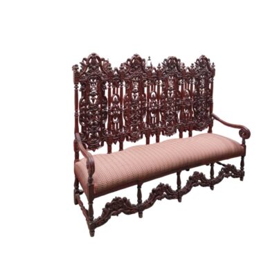 Banco antiguo presenta una elaborada estructura de madera tallada en estilo barroco español o renacentista, con un respaldo alto ornamentado y asiento tapizado alquiler para eventos, publicidad, peliculas y series