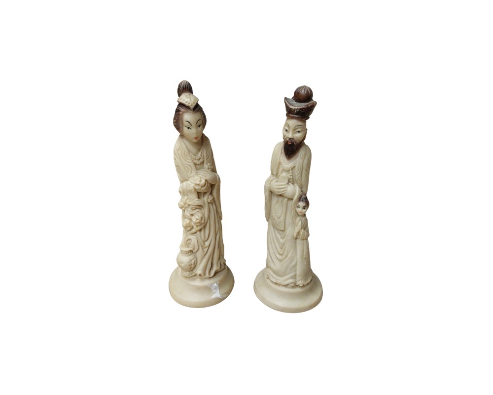 A pair of decorative pieces depicting two human figures dressed in traditional attire, carved from a material that mimics the appearance of ivory; available for hire for events, advertising, films and TV series