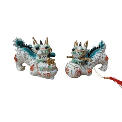 Two porcelain figurines depicting the Qilin, a mythical creature from Eastern mythology that symbolises prosperity and good fortune. The figurines are finely detailed with glazes in shades of white, green and gold; available for hire for events, advertising, films and TV series