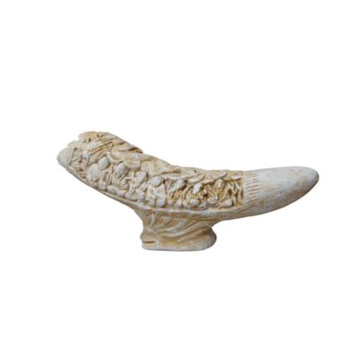 An ornamental sculpture with an elongated, curvilinear design, resting on a carved central plinth, finished in light, ivory-coloured tones; available for hire for events, advertising, films and TV series