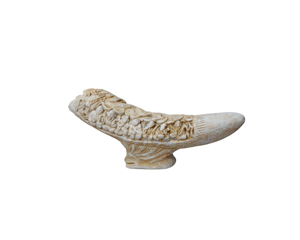 An ornamental sculpture with an elongated, curvilinear design, resting on a carved central plinth, finished in light, ivory-coloured tones; available for hire for events, advertising, films and TV series