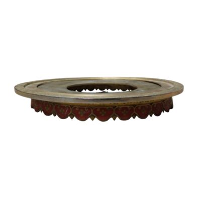 Conjunto de soporte compuesto por dos piezas: un anillo metálico superior con grabados geométricos y una base circular con bordes decorados en tonos rojizos. Diseñado con una apertura central, este elemento sirve como pedestal ornamental para realzar la presentación de piezas decorativas, como jarrones o cuencos, sobre superficies de apoyo. alquiler para eventos, publicidad, peliculas y series