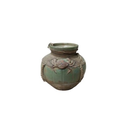 A ceramic vase with a green-toned glaze, characterised by a globular body and a distinctive design featuring a relief sculpture of a crab on the front, surrounded by elements resembling nets; available for hire for events, advertising, films and TV series