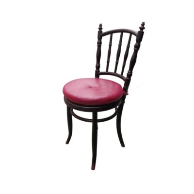 This vintage Thonet-style chair is made from bentwood and features a striking round seat upholstered in red leather; available for hire for events, advertising, films and TV series