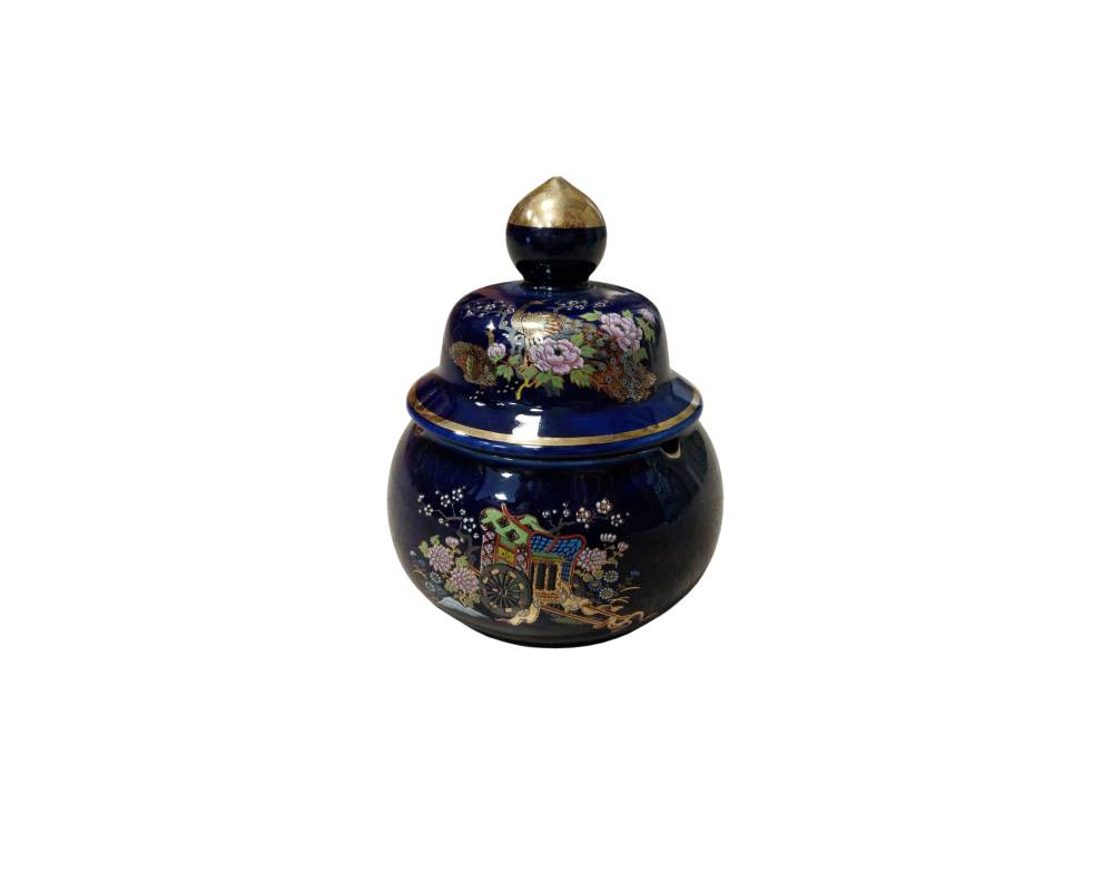 A ceramic sweet dish with a spherical body and a glossy finish in a deep dark blue shade, featuring a stepped lid with a gold-coloured knob at the top; available for hire for props, advertising, films and TV series