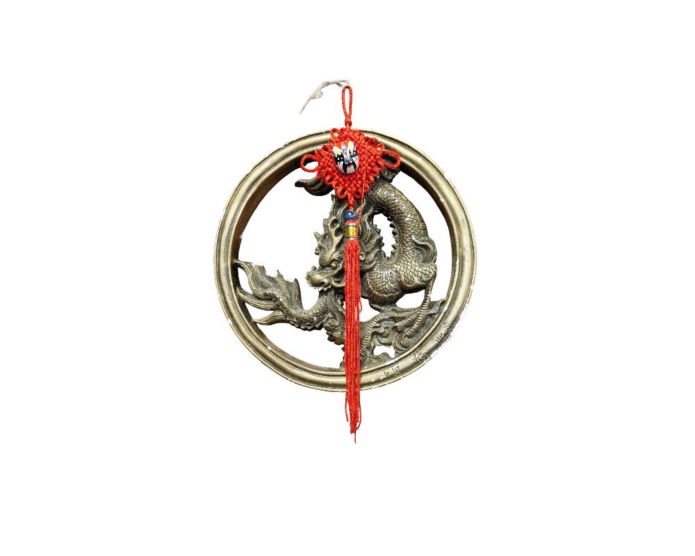 pieza decorativa de pared que consiste en un marco circular de metal con un relieve central detallado que representa a un dragón, figura icónica de la mitología oriental alquiler para eventos, publicidad, peliculas y series
