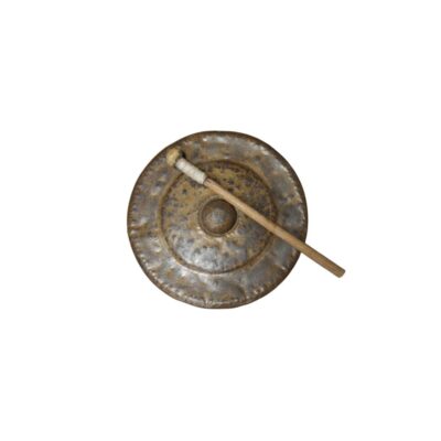 A circular metal gong with an aged patina in shades of gold and dark colours, characterised by a hand-hammered design, a prominent central raised section and a textured rim, accompanied by its matching wooden mallet with a wrapped handle; available for hire for events, advertising, films and TV series