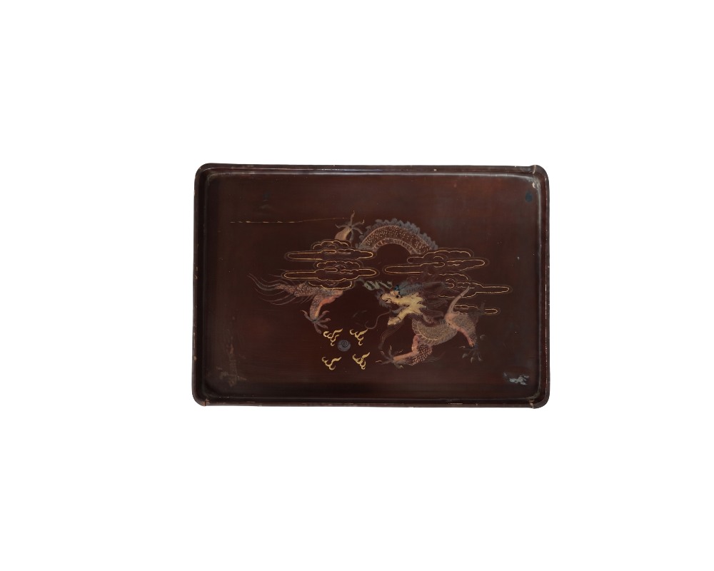bandeja rectangular de superficie lisa y tonos oscuros, caracterizada por una detallada ilustración central que representa un dragón oriental estilizado entre nubes y motivos tradicionales alquiler para eventos, publicidad, peliculas y series