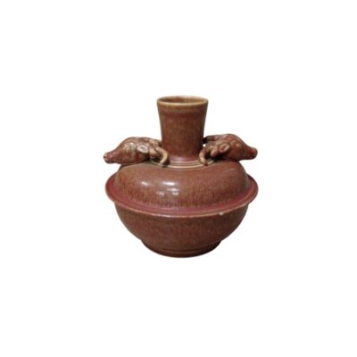 jarrón de cerámica de cuerpo globular con tapa y cuello cilíndrico, caracterizado por un llamativo acabado de esmalte jaspeado en tonos rojos y marrones, y dos asas laterales esculpidas con formas de animales alquiler para eventos, publicidad, peliculas y series