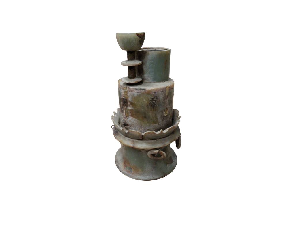 An ornamental and sculptural stone object with a marbled finish in greenish and earthy tones, giving it an antique appearance, characterised by a complex, multi-layered structure comprising cylindrical sections, overlapping rings, linear engravings and subtle markings on its surface; available for hire for events, advertising, films and TV series