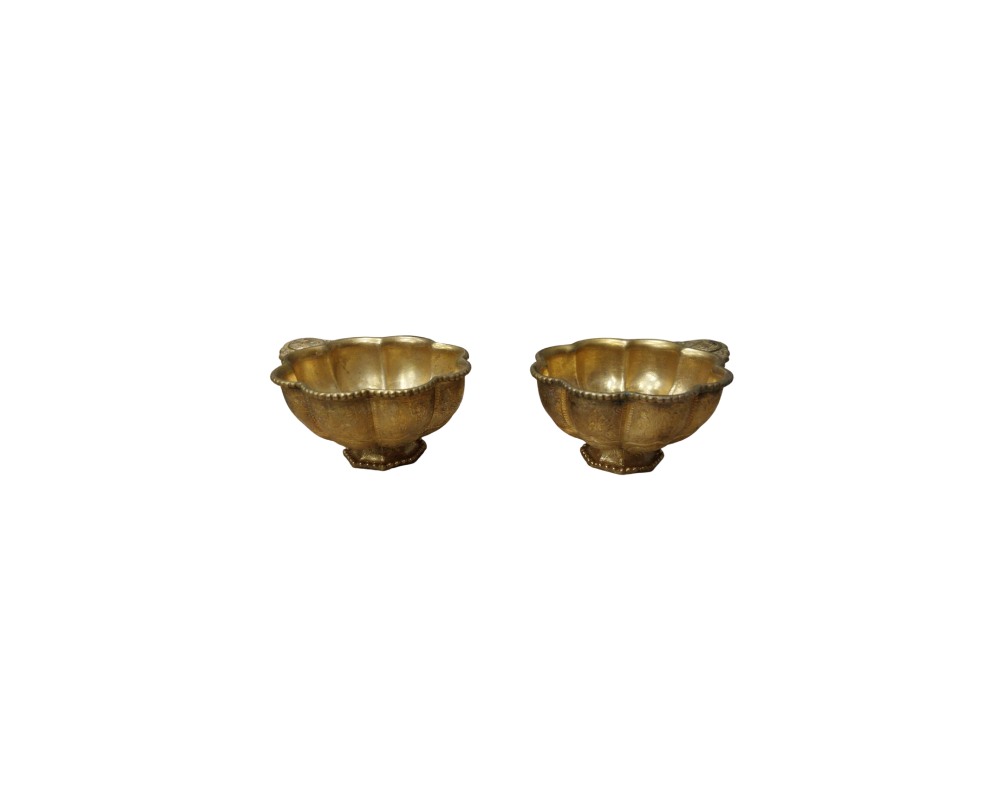 compuesto por dos pequeñas tazas metálicas con un acabado brillante de tono dorado, caracterizados por un diseño lobulado en forma de pétalos y una pequeña pestaña o asa lateral ornamentada alquiler para eventos, publicidad, peliculas y series