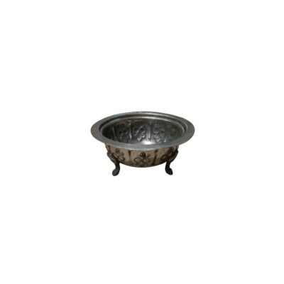 A circular metal bowl with a silver-coloured, distressed finish, characterised by a flat, wide rim, a body decorated with floral reliefs on both the inside and outside, and three small, stylised supporting legs; available for hire for events, advertising, films and TV series