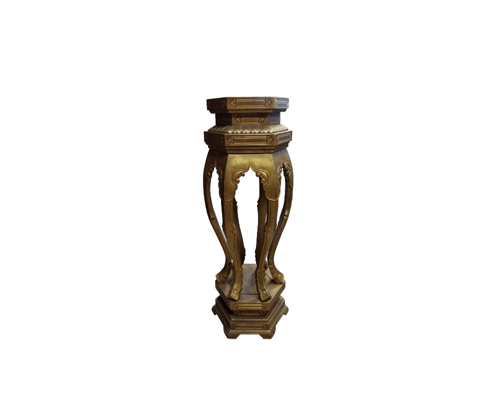 pedestal alto con una pátina en tonos dorados y oscuros, caracterizado por una plataforma superior poligonal, patas estilizadas de diseño curvo con adornos ornamentales y una base sólida a juego alquiler para eventos, publicidad, peliculas y series