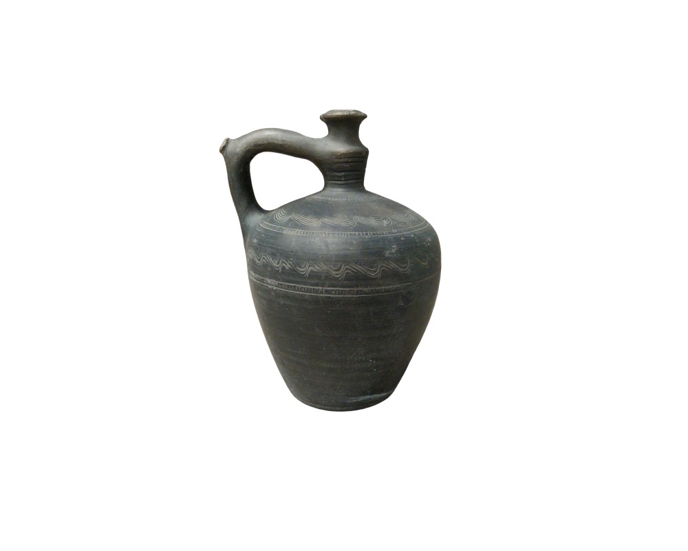 A ceramic jug in dark and grey tones, with a stylised globular body, a small opening at the top and a raised side handle that connects to the neck; available for hire for events, advertising, films and TV series