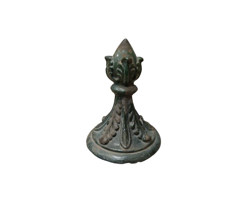 A sculptural metal ornament with a dark, aged patina, characterised by a domed circular base and a vertical body decorated with delicate reliefs of leaves and floral motifs, culminating in a pointed top; available for hire for events, advertising, films and TV series