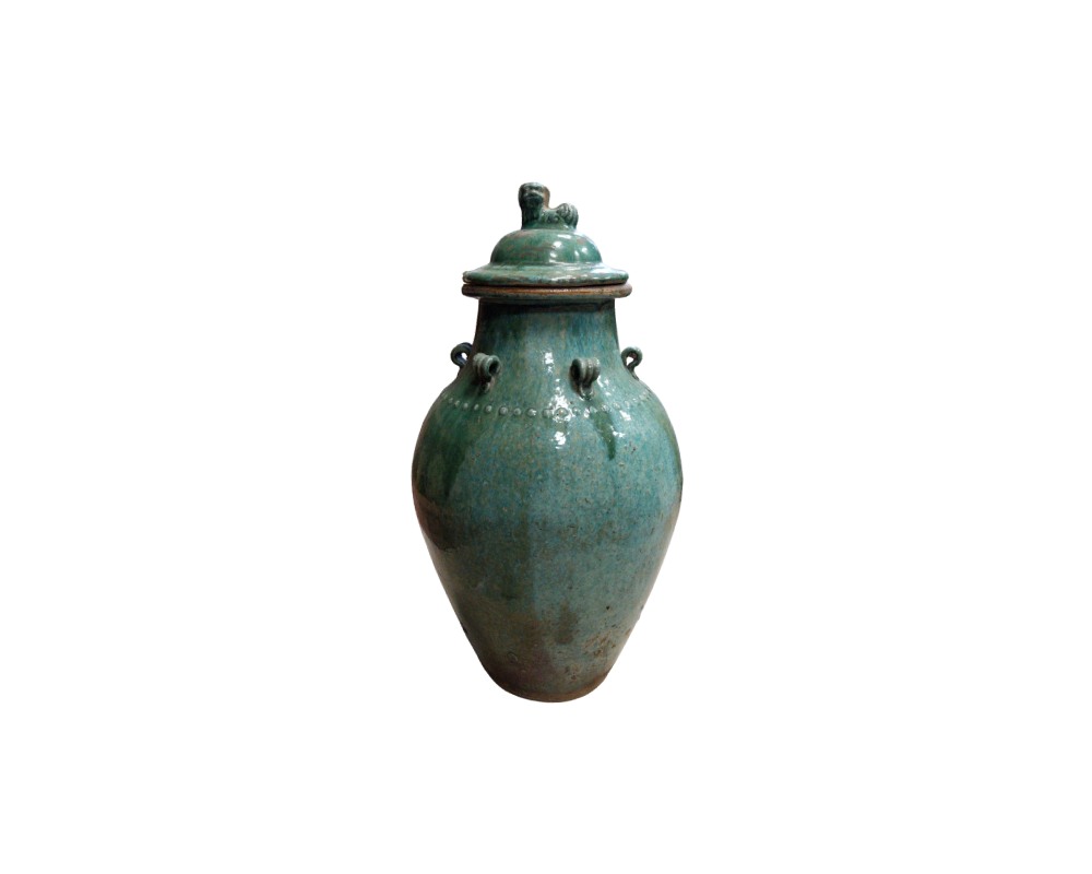 A ceramic vase with a glossy glaze in shades of turquoise green and an aged patina, characterised by a globular body, small decorative handles or rings on the shoulder, a line of raised dots and a lid crowned by a small sculpted figure; available for hire for events, advertising, films and TV series