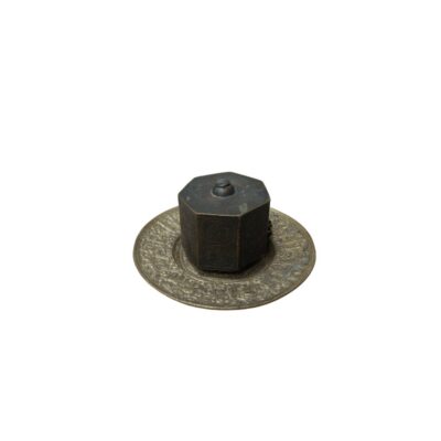 conjunto decorativo de metal con un acabado envejecido en tonos oscuros, compuesto por un plato circular de borde amplio profusamente grabado con detalles en relieve y un recipiente central de forma hexagonal con tapa superior alquiler para eventos, publicidad, peliculas y series