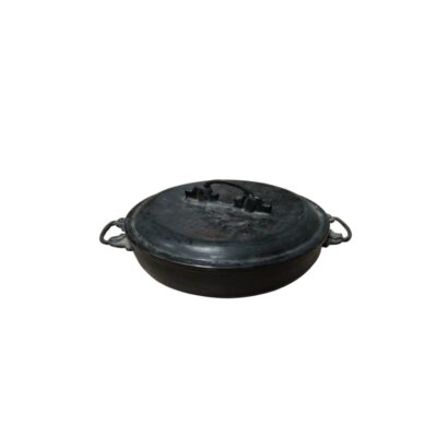 A metal saucepan with a distressed finish in dark tones, characterised by a shallow circular shape, two small side handles for gripping, and a snug-fitting lid featuring a central arched handle; available for hire for events, advertising, films and TV series