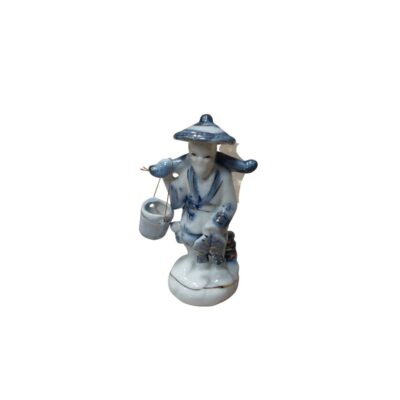 A porcelain figurine painted in the classic style, featuring blue motifs on a white background. The figurine depicts a traditional fisherman wearing a conical hat, carrying a pole over his shoulders from which a bucket hangs, whilst holding a fish in his hand. Available for hire for events, advertising, films and TV series.