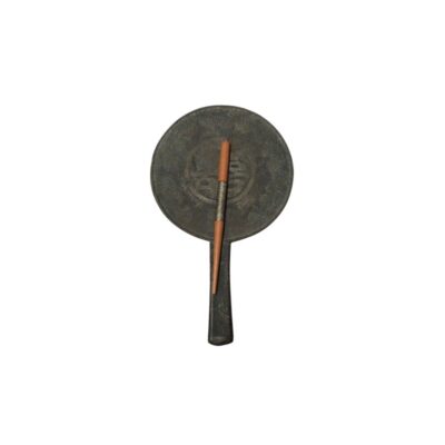 Dark metal mirror with a circular body and integrated handle, featuring a surface engraved with traditional motifs in relief; available for hire for events, advertising, films and TV series