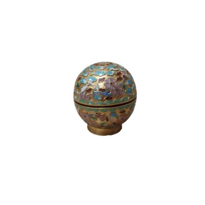 A small spherical box crafted using the cloisonné enamel technique, featuring an intricate decoration of floral and geometric motifs in various colours on a gilded metal frame. With its refined design and compact size, it serves as an ornamental collector’s item, ideal for storing small objects or as a decorative table centrepiece. Available for hire for events, advertising, films and TV series.