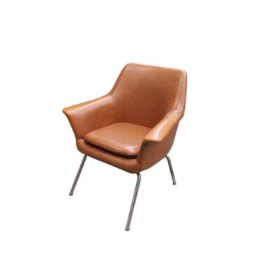 sillón butaca de época, caracterizado por un cuerpo envolvente tapizado en cuero o polipiel de tono marrón cálido con cojín de asiento independiente, integrado sobre una esbelta estructura de soporte metálica de cuatro patas cónicas alquiler para eventos, publicidad, peliculas y series