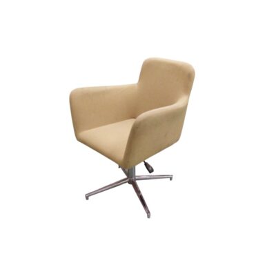 A modern vintage-style armchair, characterised by a wraparound, one-piece body with integrated armrests, upholstered in cream-coloured fabric; available for hire for events, advertising, films and TV series