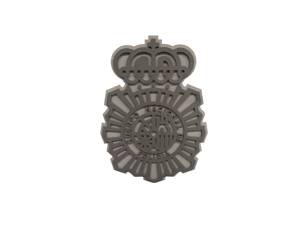 A die-cut or embossed reproduction of the official coat of arms of the Spanish National Police Force in shades of grey, characterised by its openwork geometric design featuring the eight-pointed star and the royal crown above it; available for hire for events, advertising, films and TV series