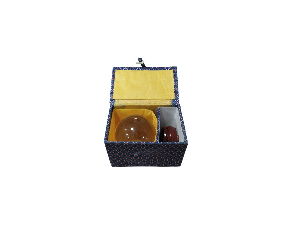 esfera decorativa de cristal tallado que muestra interesantes vetas o inclusiones blanquecinas en su interior, presentada sobre una pequeña base alquiler para eventos, publicidad, peliculas y series