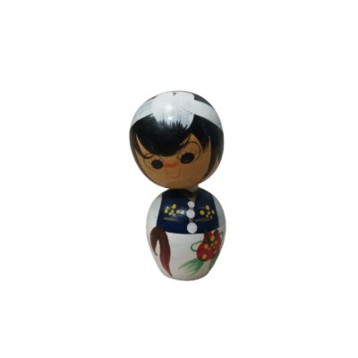 A traditional decorative figure in the kokeshi style, carved from wood, characterised by a bulbous body and a spherical head, hand-painted with expressive facial features, dark hair, and floral and ornamental motifs on its clothing; available for hire for events, advertising, films and TV series