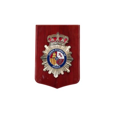 metopa decorativa de forma rectangular con base de madera en tonos rojizos, caracterizada por incorporar en su parte central un emblema metálico plateado y esmaltado a todo color del Cuerpo Nacional de Policía de España, rematado con la corona real superior alquiler para eventos, publicidad, peliculas y series