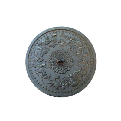 A circular metal mirror with a shiny silver finish, featuring an intricate embossed design on its surface; available for hire for events, advertising, films and TV series