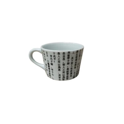 pequeña taza de cerámica de esmalte blanco brillante con un asa lateral, caracterizada por una distintiva y densa decoración exterior formada por líneas de texto o caracteres caligráficos en tonos oscuros de inspiración oriental alquiler para eventos, publicidad, peliculas y series